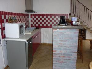 La cuisine est équipée d'un réfrigérateur et d'un comptoir avec un four micro-ondes. dans l'établissement Gîte Ébreuil, 3 pièces, 4 personnes - FR-1-489-19, à Ébreuil