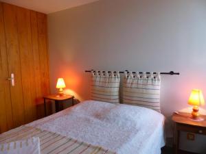 a bedroom with a bed with two lamps on two tables at Gîte Dompierre-sur-Besbre, 4 pièces, 6 personnes - FR-1-489-51 in Dompierre-sur-Besbre