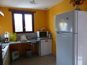 a kitchen with a refrigerator and a microwave at Gîte Dompierre-sur-Besbre, 4 pièces, 6 personnes - FR-1-489-51 in Dompierre-sur-Besbre