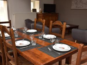 - une table en bois avec des assiettes et des verres à vin dans l'établissement Gîte Cressanges, 4 pièces, 6 personnes - FR-1-489-78, à Cressanges