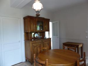 a dining room with a wooden table and a cabinet at Charmante maison rénovée avec jardin clos, 3 chambres, proche sites touristiques et villlage médiéval - FR-1-489-105 in Saint-Bonnet-de-Rochefort +15 photos