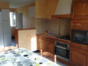 uma cozinha com uma mesa e um fogão forno superior em Gîte Creuzier-le-Neuf, 4 pièces, 6 personnes - FR-1-489-76 em Creuzier-le-Neuf