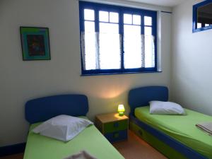 2 Betten in einem Zimmer mit Fenster in der Unterkunft Gîte Dompierre-sur-Besbre, 5 pièces, 8 personnes - FR-1-489-109 in Dompierre-sur-Besbre