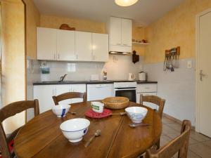 a kitchen with a wooden table with bowls on it at Gîte Montagne avec Terrasse et Barbecue - Animaux Acceptés - FR-1-489-101 in Ferrières-sur-Sichon +2 photos