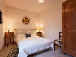 a bedroom with a white bed and a clock on the wall at Gîte Montagne avec Terrasse et Barbecue - Animaux Acceptés - FR-1-489-101 in Ferrières-sur-Sichon