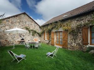 a patio with a table and chairs and an umbrella at Gîte Montagne avec Terrasse et Barbecue - Animaux Acceptés - FR-1-489-101 in Ferrières-sur-Sichon