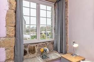 una habitación con una ventana con un jarrón de flores sobre una mesa en Bridge End Mill Apartments In Settle en Settle