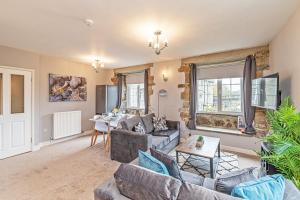 a living room with couches and a table at Bridge End Mill Apartments In Settle in Settle