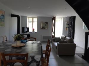 a living room with a table and a couch at Charmante fermette en montagne bourbonnaise, animaux admis - FR-1-489-136 in Lavoine
