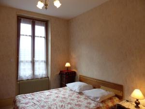 ein Schlafzimmer mit einem Bett mit zwei Kissen und einem Fenster in der Unterkunft Gîte Saint-Germain-des-Fossés, 5 pièces, 8 personnes - FR-1-489-248 in Saint-Germain-des-Fossés