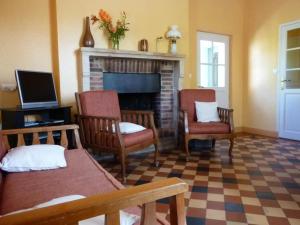 - un salon avec deux chaises et une cheminée dans l'établissement Gîte Aurouer, 3 pièces, 4 personnes - FR-1-489-258, à Aurouer