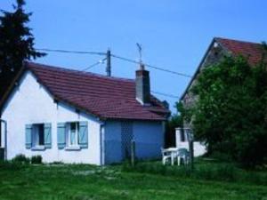 a white house with a red roof and a white chair at Maison 2 chambres avec jardin clos en Sologne, animaux acceptés - FR-1-489-258 in Aurouer