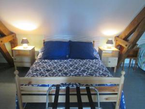 um quarto com uma cama com almofadas azuis e 2 candeeiros em Gîte Molinet, 3 pièces, 6 personnes - FR-1-489-253 em Molinet