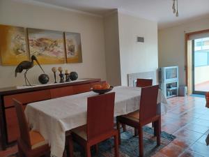 une salle à manger avec une table et des chaises blanches dans l'établissement Alojamento Varandas do Parque com INTERNET, à Póvoa de Varzim