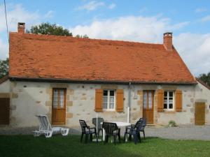 a table and chairs in front of a house at Charmante fermette au vert près de la forêt de Tronçais, 2 chambres, animaux acceptés, linge inclus - FR-1-489-311 in Vieure