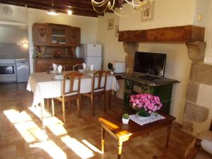 a living room with a table and a kitchen with a tableablish at Charmante fermette au vert près de la forêt de Tronçais, 2 chambres, animaux acceptés, linge inclus - FR-1-489-311 in Vieure