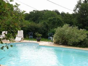 una piscina con due sedie a sdraio e due sedie di Chalet familial avec piscine, animaux acceptés, draps inclus, proche de Montluçon et Gannat - FR-1-489-323 a Échassières