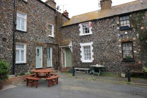 a picnic table in front of a brick building at Pickwick's Place By The Sea Broadstairs in Broadstairs