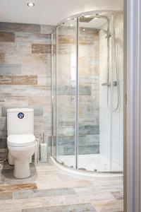 a bathroom with a toilet and a shower at Pickwick's Place By The Sea Broadstairs in Broadstairs