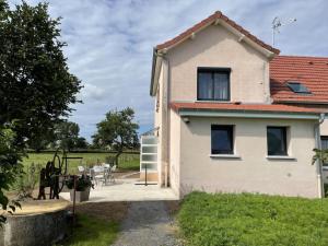 a white house with a patio and a table at Gîte champêtre rénové avec jardin et BBQ, proche parc Le PAL - FR-1-489-347 in Pierrefitte-sur-Loire