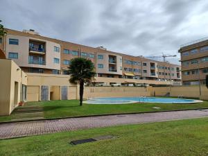 un complexe d'appartements avec une piscine en face d'un bâtiment dans l'établissement Alojamento Varandas do Parque com INTERNET, à Póvoa de Varzim