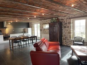 a living room with a couch and a table with chairs at Gîte Marcillat-en-Combraille, 3 pièces, 6 personnes - FR-1-489-369 in Marcillat-en-Combraille