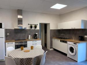 - une cuisine avec une table et un lave-linge dans l'établissement Gîte Villeneuve-sur-Allier, 3 pièces, 4 personnes - FR-1-489-372, à Villeneuve-sur-Allier