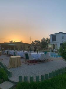 eine Gruppe von Tischen und Stühlen auf einer Terrasse in der Unterkunft Magnifique villa avec piscine in Kenitra