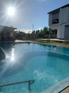 uma grande piscina de água azul em frente a um edifício em Magnifique villa avec piscine em Kenitra