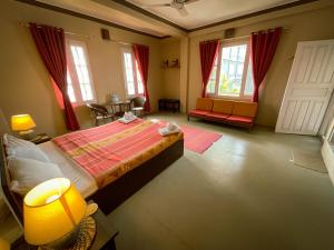 una camera da letto con un letto, un tavolo e finestre di New Hotel Castle a Pokhara Altre 17 foto