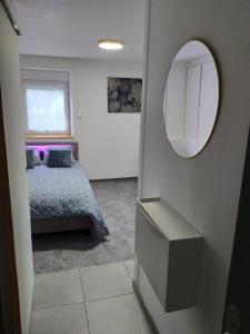 Schlafzimmer mit einem Bett und einem Spiegel in der Unterkunft *** STUDIO 39 *** in Morbier