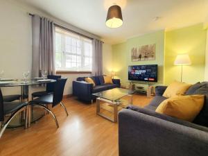 a living room with a couch and a table at Parkgate Apartment - Near M90, Amazon, Edinburgh in Rosyth