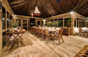 雅庫馬的住宿－Qavi - Villa Jacumã #Luxo，一间带长桌和椅子的用餐室