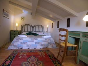 - une chambre avec un lit et un fauteuil en bois dans l'établissement Il Bruco appartamenti in b&b, à San Donato Val di Comino