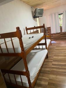 a bedroom with two bunk beds and a tv at Pesque pague pousada do Carlinho in Pinheiral