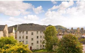 a group of buildings and trees with mountains in the background at University and Central Edinburgh in Edinburgh