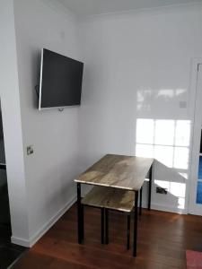 una mesa de madera en una habitación con TV en la pared en University and Central Edinburgh, en Edimburgo