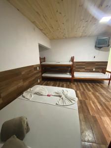 two beds in a room with wooden floors at Pesque pague pousada do Carlinho in Pinheiral
