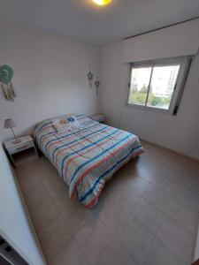 Cama en habitación blanca con ventana en Departamento nuevo en Cordoba en Córdoba