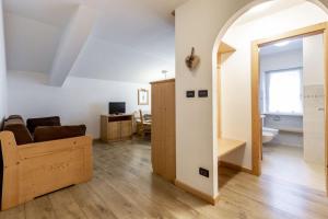 an open living room with a couch and a mirror at Stella Alpina in Campitello di Fassa