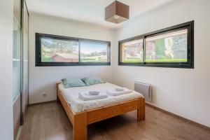 1 dormitorio con 1 cama y 2 ventanas en Superb chalet with pool - Welkeys, en Alex