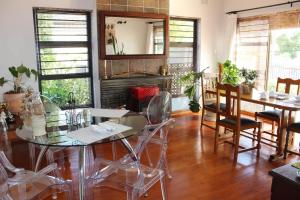 a dining room with a glass table and chairs at Amru Guesthouse B&B in Brackenfell