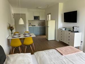 a room with a bed and a kitchen with a table and chairs at APARTMÁNY ŠÁRKA in Trojanovice