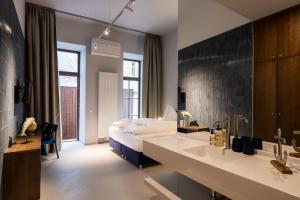 a bedroom with a bed and a bathroom with a sink at grätzlhotel Serviten in Vienna