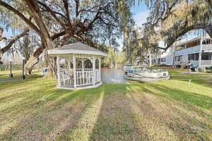 a gazebo in the middle of a yard with a boat at Cypress Cove Waterfront Townhome with Boat Ramp in Inverness