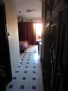 Marrakech Hôtel Résidence في مراكش: ممر به غرفة بها سرير وأرضية من البلاط