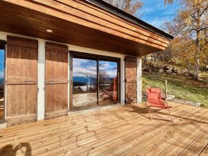 a red chair sitting on a wooden deck at La bergerie d'Egat: Chalet authentique avec vue in Égat