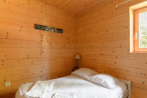 LʼHuezにあるChalet Sherpa - Welkeysの窓付きのログキャビンのベッド1台分です。