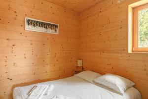 sypialnia z łóżkiem w drewnianym domku w obiekcie Chalet Sherpa - Welkeys w mieście LʼHuez