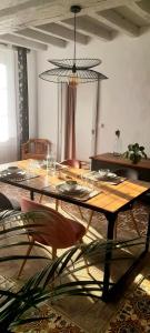 uma sala de jantar com uma mesa com copos em Gîte Sous le Tilleul - Tourouvre - Perche em La Ventrouze
